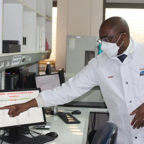 Dr. Sikhulile Moyo points to a computer, describes his team’s findings during a visit by President of Botswana, Mokgweetsi Masisi, December 2, 2021. Botswana Harvard Partnership/Tapela Morapedi